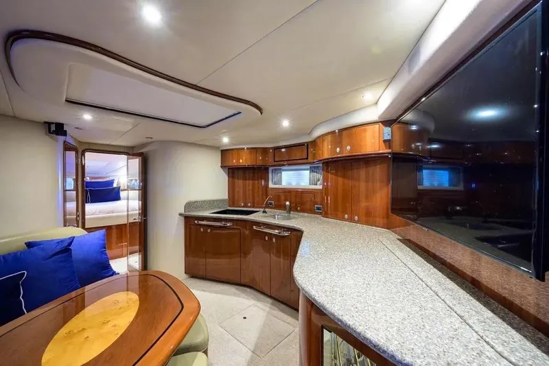 Still The One Yacht Photos Pics Luxurious interior of 2004 Sea Ray 550 Sundancer yacht with modern kitchen and seating area.
