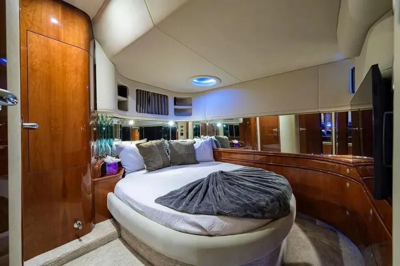 Still The One Yacht Photos Pics Luxurious bedroom interior of 2004 Sea Ray 550 Sundancer yacht with round bed and wood finish.