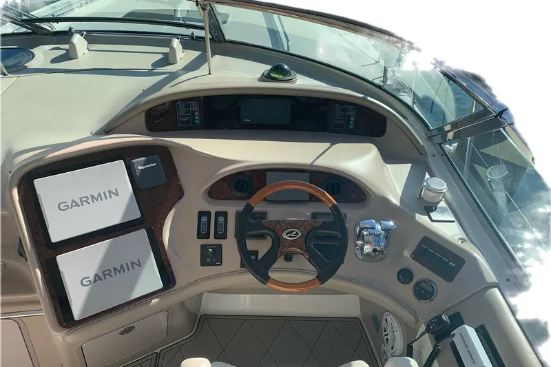 Still The One Yacht Photos Pics 2004 Sea Ray 550 Sundancer helm with Garmin navigation and wood-accented steering wheel.