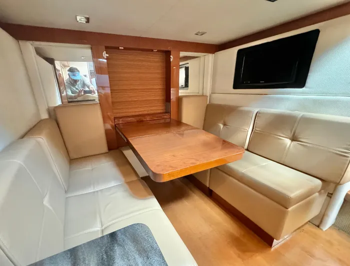 Yacht Photos Pics Interior of 2013 Sea Ray 410 Sundancer with beige seating and wooden table.