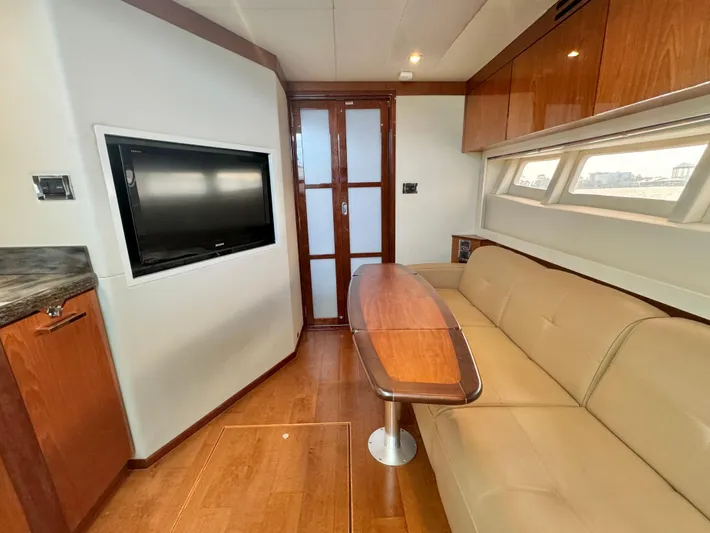  Yacht Photos Pics Luxurious interior of 2013 Sea Ray 410 Sundancer with TV, sofa, and wooden finishes.