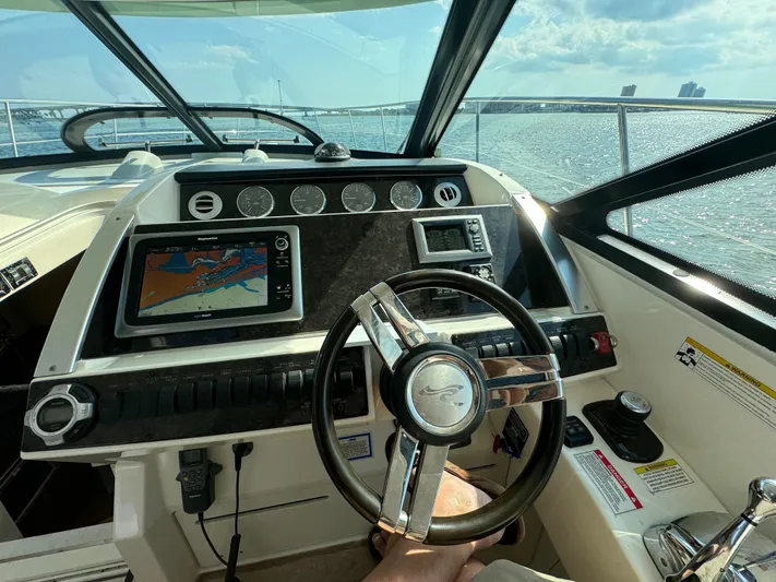  Yacht Photos Pics 2013 Sea Ray 410 Sundancer helm with navigation system and steering wheel, overlooking the ocean.