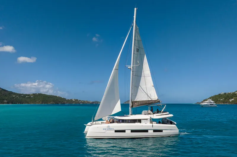 Aquanimity Yacht Photos Pics 2021 Dufour 48 sailing catamaran on turquoise waters under clear blue sky.