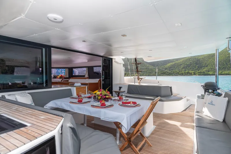 Aquanimity Yacht Photos Pics Luxurious 2021 Dufour 48 yacht interior with elegant dining setup and scenic ocean view.