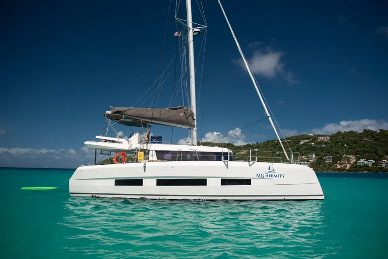 Aquanimity Yacht Photos Pics 2021 Dufour 48 catamaran "Aquanimity" sailing in turquoise waters under clear blue sky.