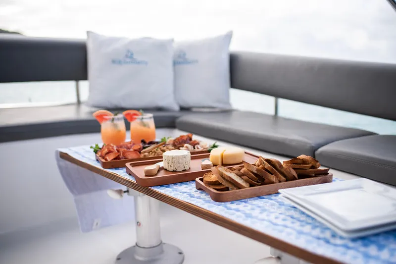 Aquanimity Yacht Photos Pics Luxury dining setup on a 2021 Dufour 48 yacht with cheese and drinks.