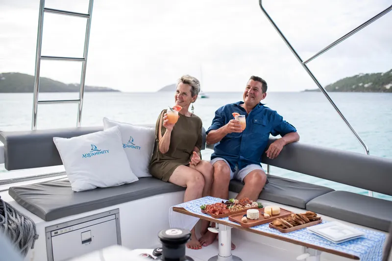 Aquanimity Yacht Photos Pics Couple enjoying drinks on a 2021 Dufour 48 yacht with ocean view.