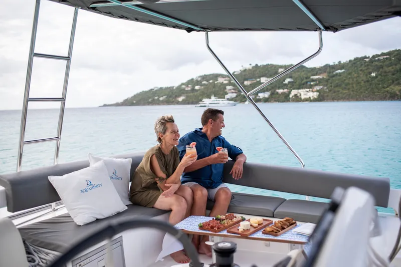 Aquanimity Yacht Photos Pics Couple enjoying drinks on a 2021 Dufour 48 yacht with ocean view.