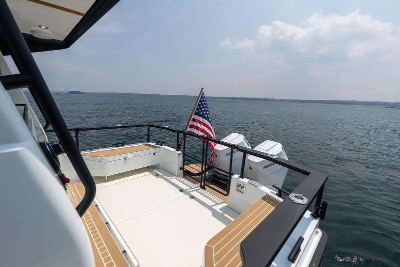 Stock 6 Yacht Photos Pics 2026 Targa 32 GT yacht deck with American flag, overlooking serene ocean waters.