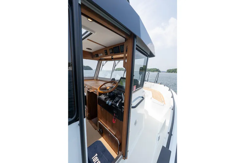 Stock 6 Yacht Photos Pics 2026 Targa 32 GT boat interior with wooden dashboard and steering wheel on open water.