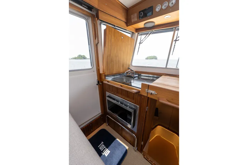 Stock 6 Yacht Photos Pics Interior of 2026 Targa 32 GT boat with wooden cabinetry and compact kitchen area.