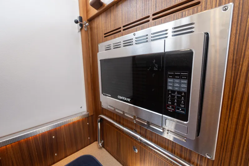 Stock 6 Yacht Photos Pics Built-in microwave in 2026 Targa 32 GT boat interior with wood paneling.