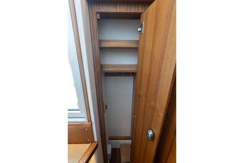 Stock 6 Yacht Photos Pics Wooden interior storage space in 2026 Targa 32 GT boat, featuring shelves and a door.