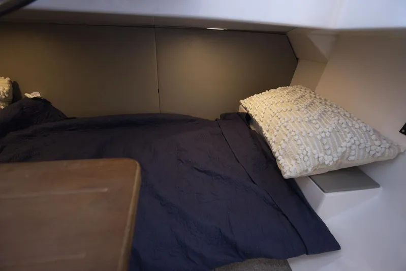  Yacht Photos Pics Cozy cabin interior of 2025 SeaWell 345XL with navy bedding and textured pillow.