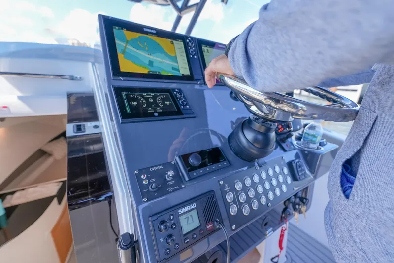  Yacht Photos Pics Person steering SeaWell 345XL boat with advanced navigation system, 2025 model.