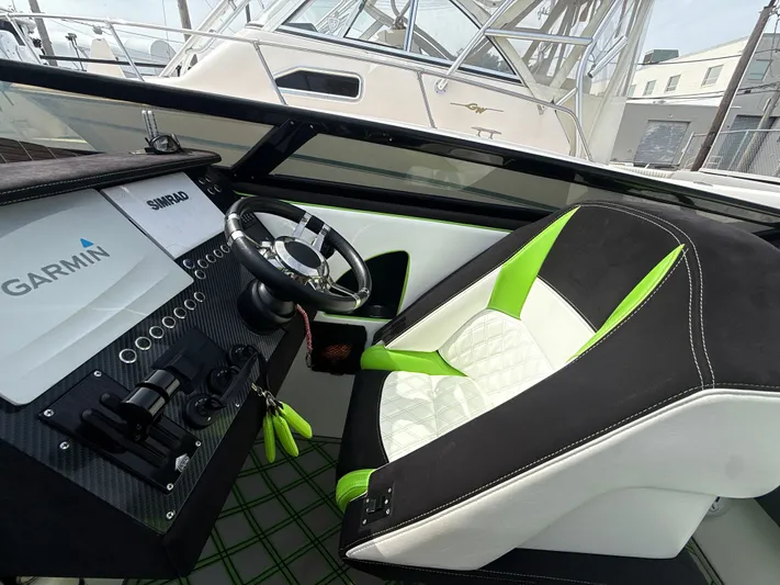  Yacht Photos Pics Cockpit of a 2000 Fountain Lightning boat with green and white seating.