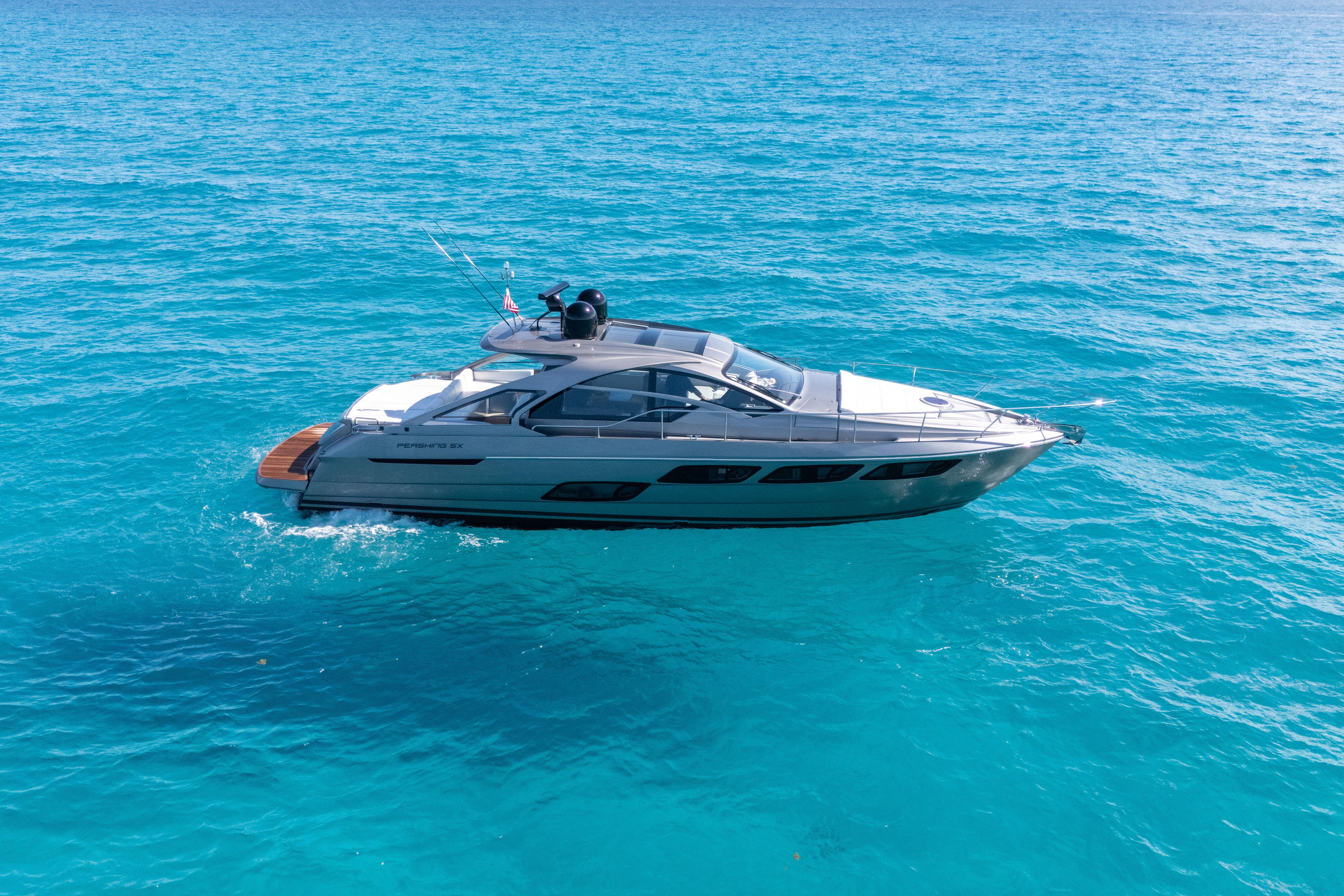 2019 Pershing 5x yacht cruising on clear blue ocean waters.