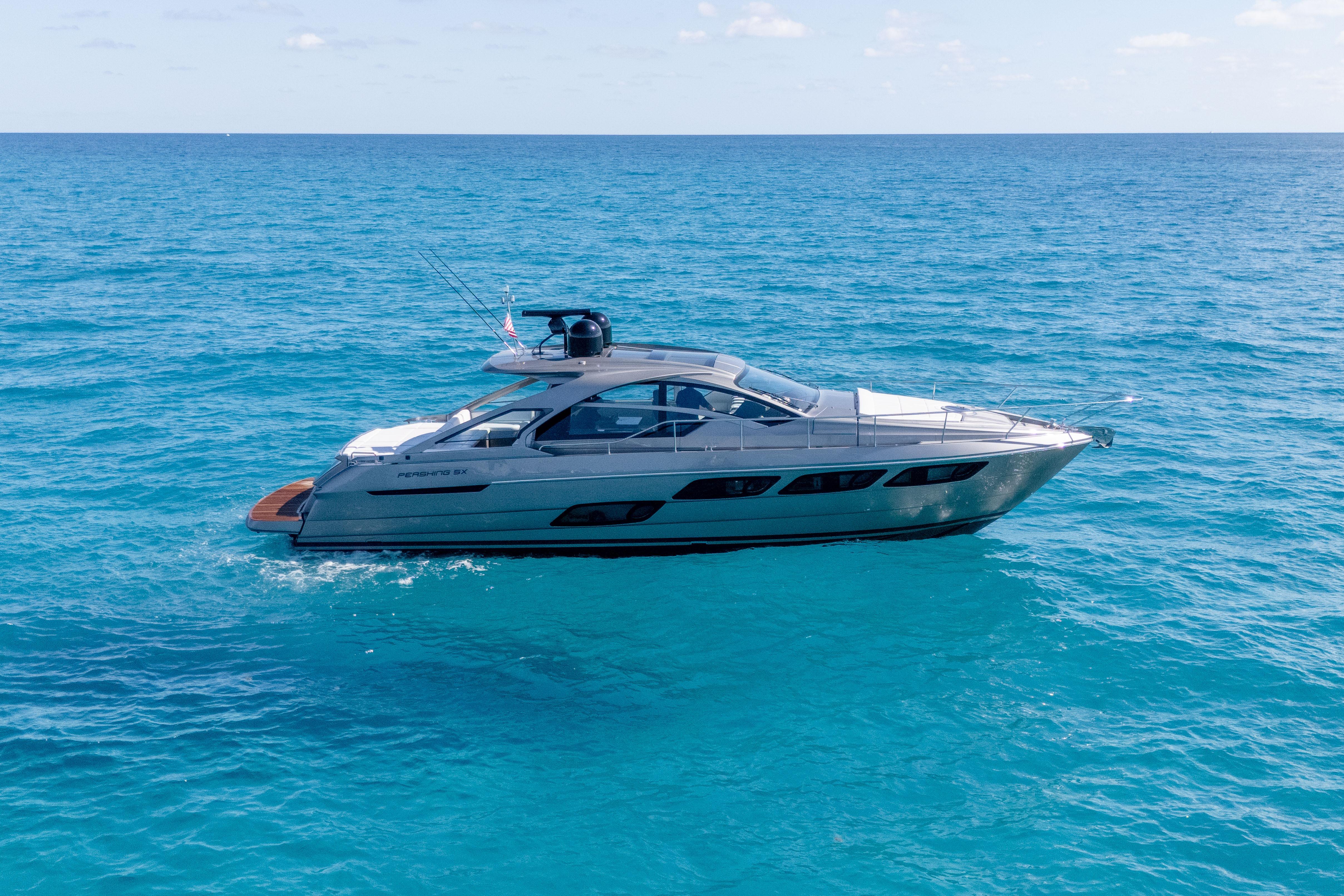 2019 Pershing 5x yacht cruising on clear blue ocean waters.