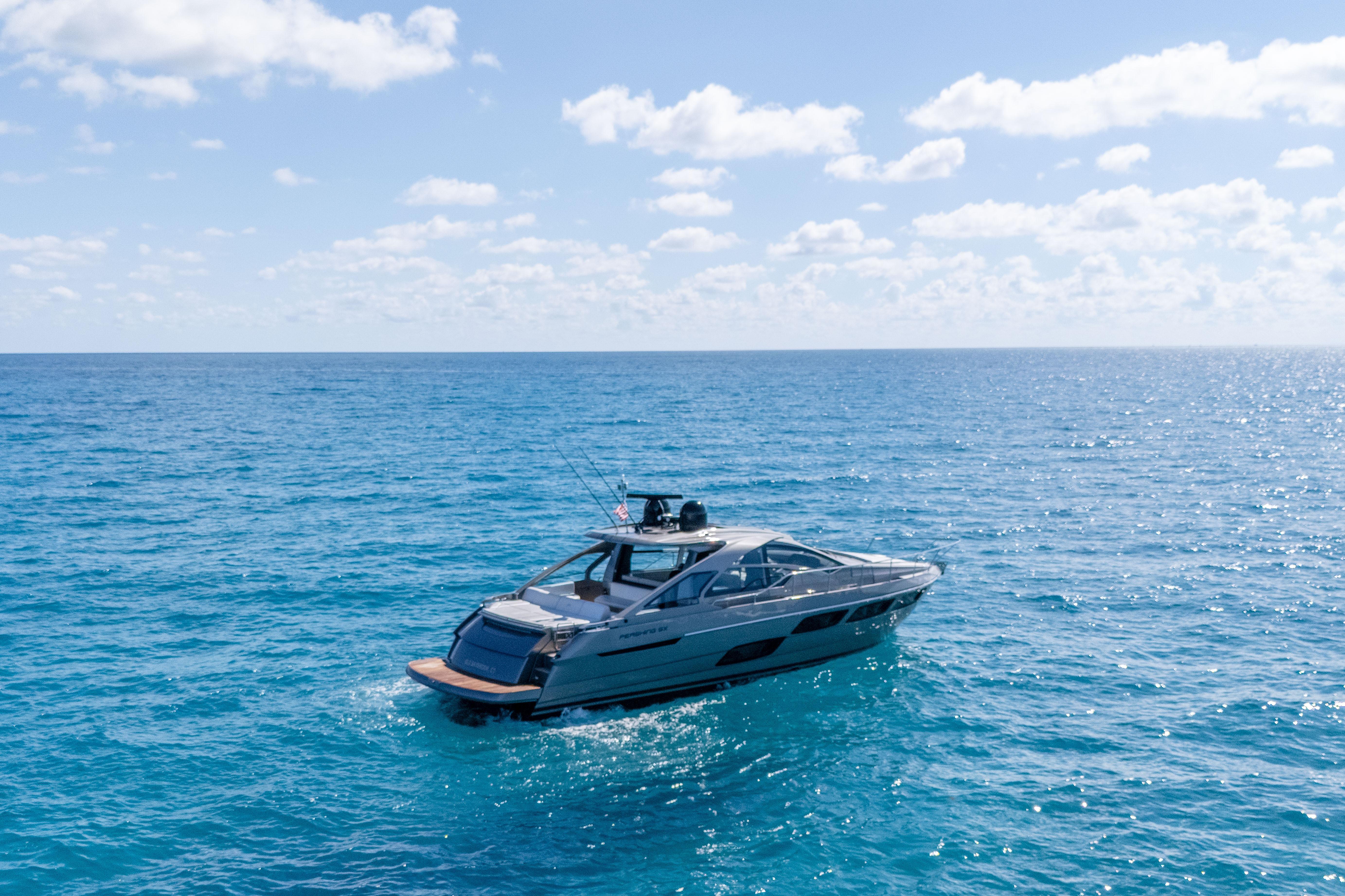 2019 Pershing 5x yacht cruising on clear blue ocean under a sunny sky.