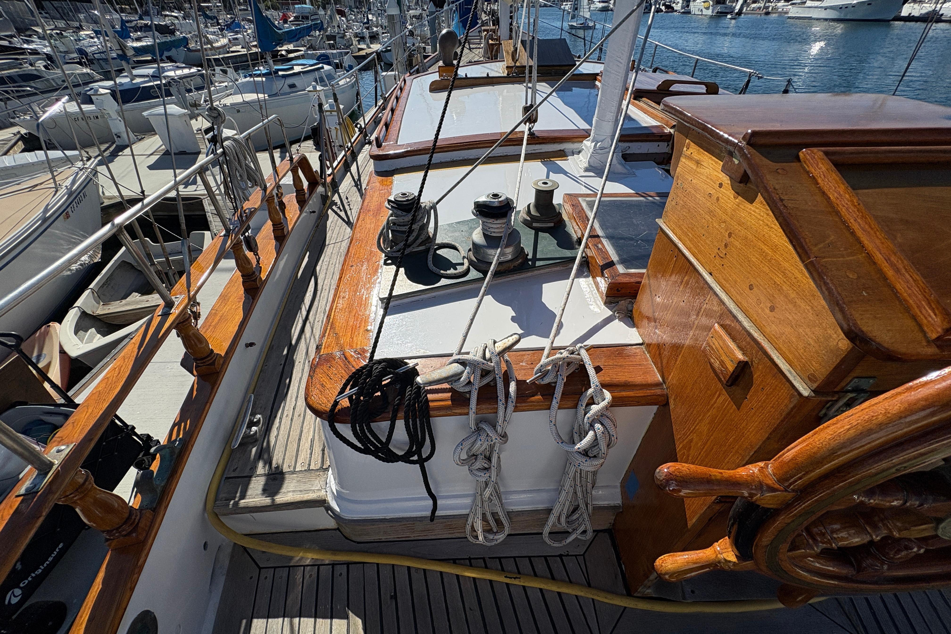 1979 Formosa 51 sailboat deck with wooden details and marina background.