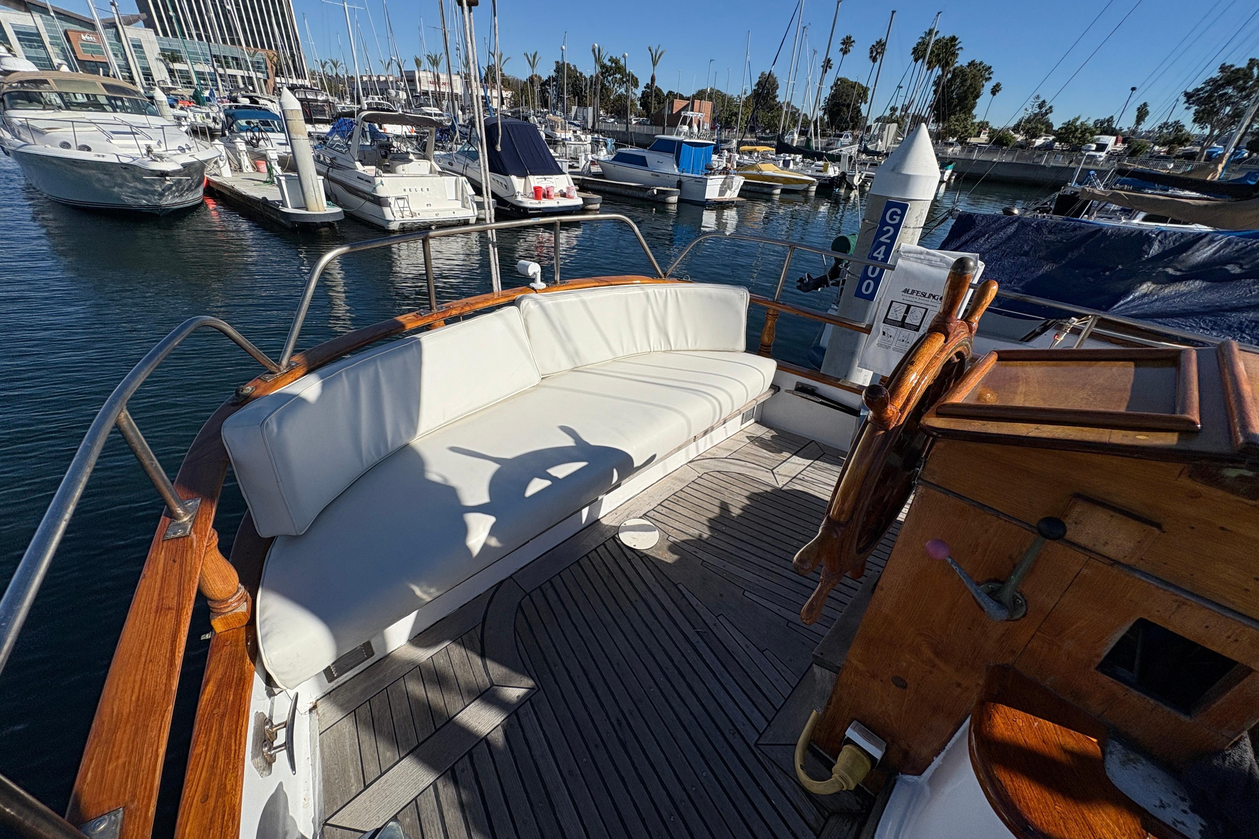 Cockpit of a 1979 Formosa 51 yacht with white seating, docked at a marina.
