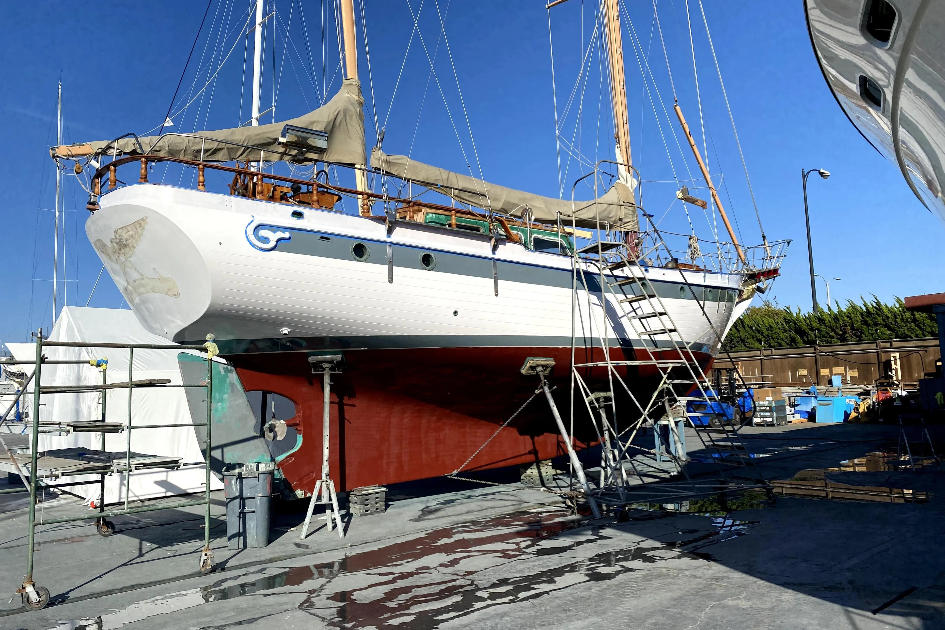 1979 Formosa 51 sailboat on dry dock for maintenance under clear blue sky.