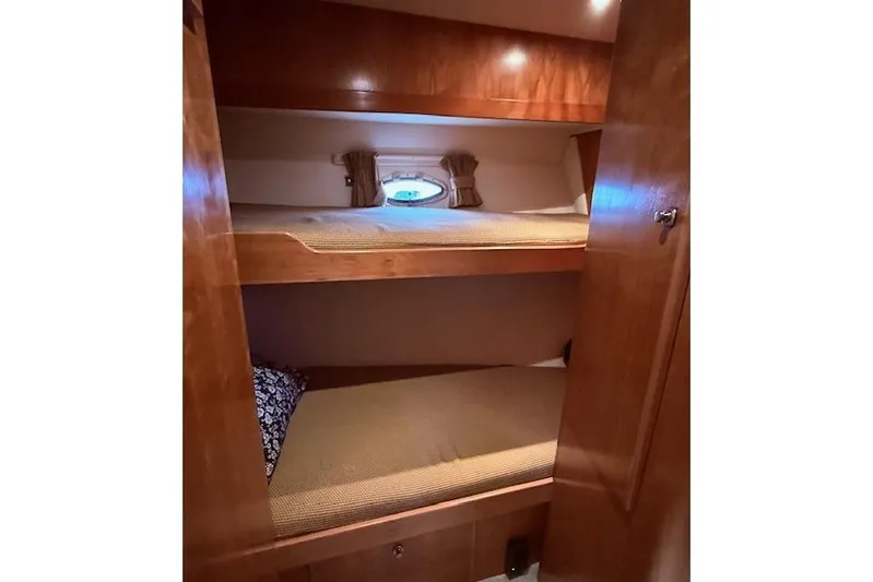  Yacht Photos Pics Bunk beds in 2007 Navigator 58 yacht cabin with wooden interior and porthole window.