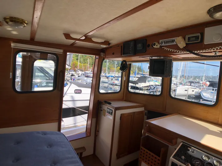  Yacht Photos Pics Interior of a 1989 Nordic Tug 32 boat with wooden accents and marina view.