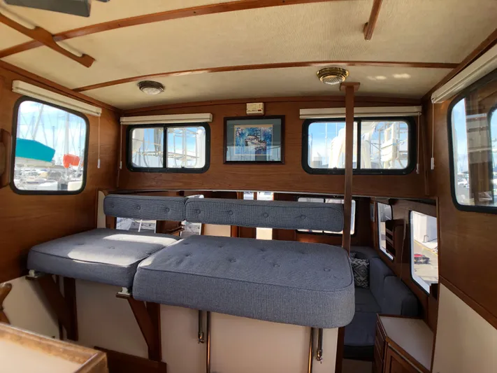  Yacht Photos Pics Interior of 1989 Nordic Tug 32 with cushioned seating and wooden accents.