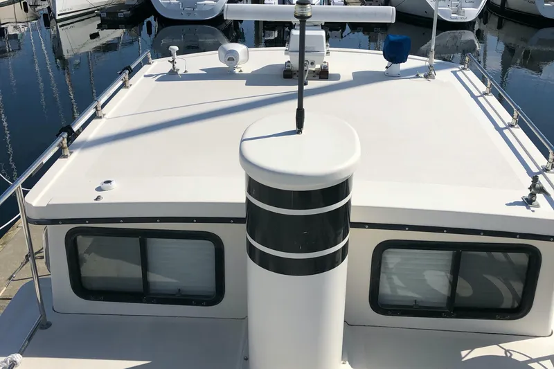  Yacht Photos Pics 1989 Nordic Tug 32 boat deck with windows and railing in marina.
