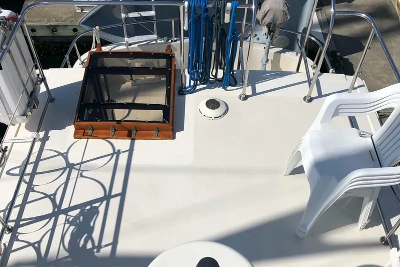  Yacht Photos Pics Deck of 1989 Nordic Tug 32 with hatch, railing, and stacked chairs.