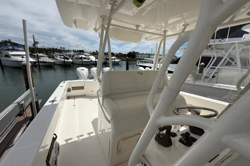  Yacht Photos Pics 2024 SeaVee 390Z boat interior at marina, showcasing seating and controls.