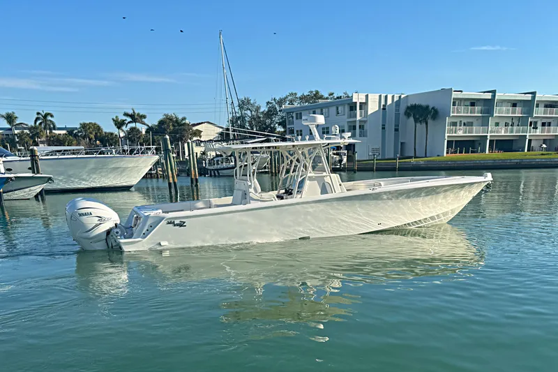  Yacht Photos Pics 2024 SeaVee 390Z boat on calm water near modern buildings.