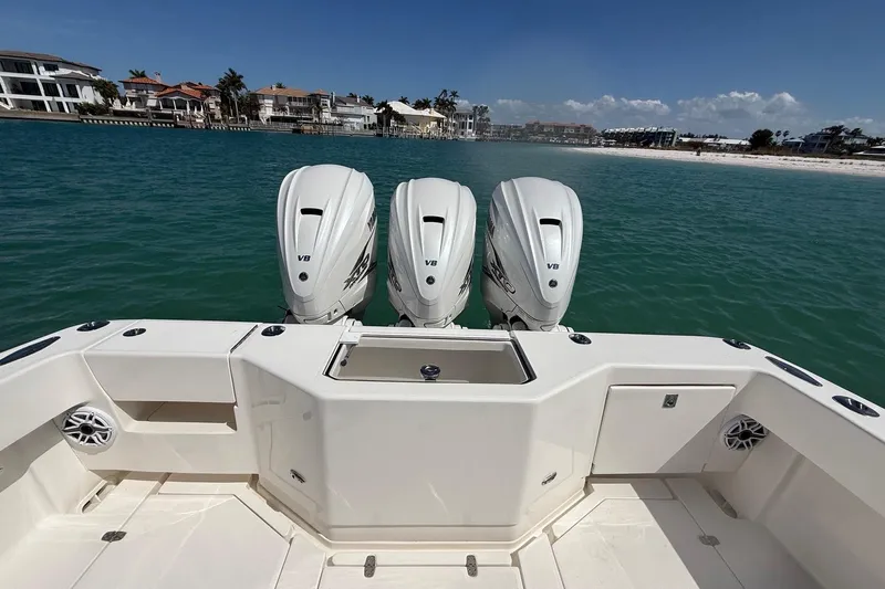  Yacht Photos Pics 2024 SeaVee 390Z boat with triple V8 engines, docked near a scenic waterfront.