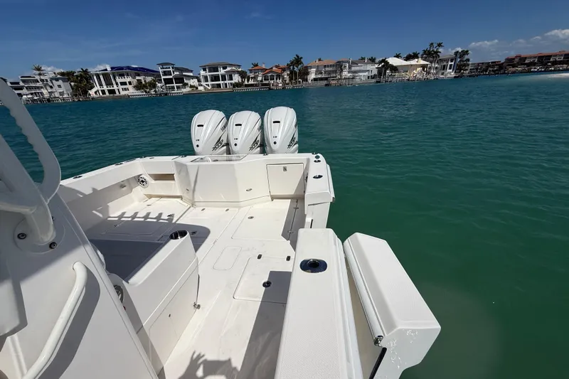  Yacht Photos Pics 2024 SeaVee 390Z boat with triple engines, docked near waterfront homes.