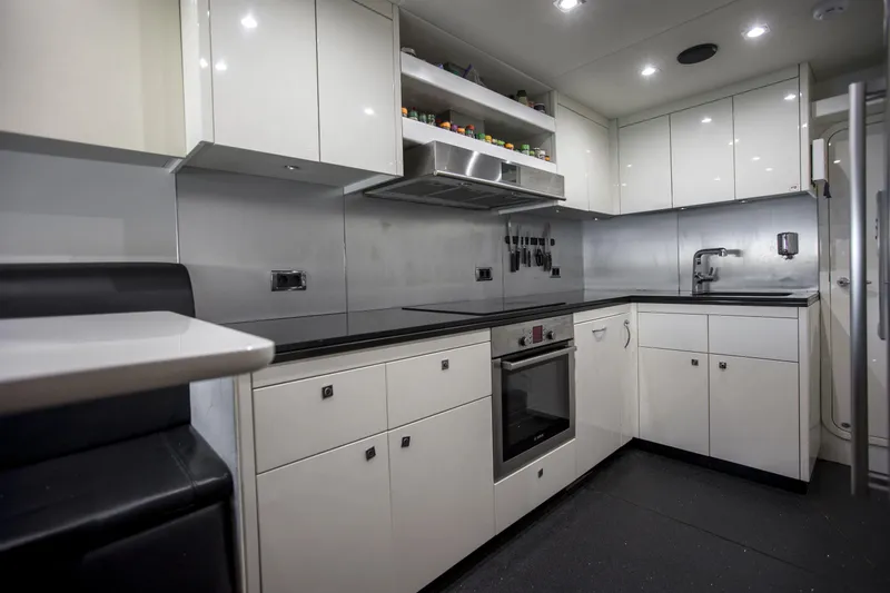 P'ocean Yacht Photos Pics Modern kitchen in a 2009 Sunseeker Predator 84 yacht, featuring sleek white cabinetry.