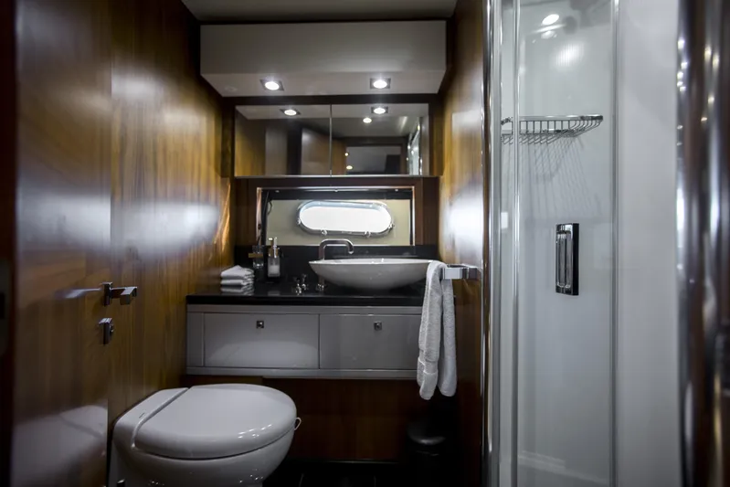 P'ocean Yacht Photos Pics Luxurious bathroom in 2009 Sunseeker Predator 84 yacht with modern fixtures and wood paneling.