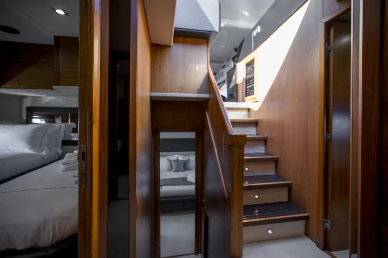 P'ocean Yacht Photos Pics Luxurious interior of 2009 Sunseeker Predator 84 yacht with wooden stairs and cozy bedroom.