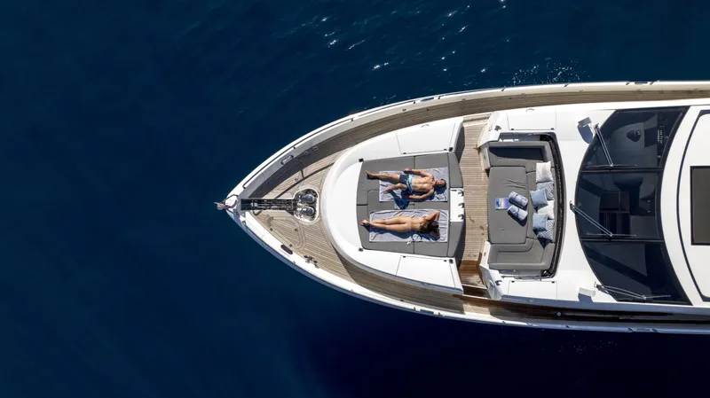 P'ocean Yacht Photos Pics Aerial view of 2009 Sunseeker Predator 84 yacht with people sunbathing on deck.