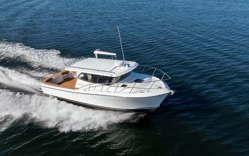  Yacht Photos Pics 2025 Ocean Sport Roamer cruising on open water, showcasing sleek design and performance.