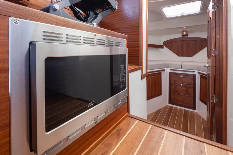  Yacht Photos Pics 2025 Ocean Sport Roamer interior with microwave, wooden cabinetry, and modern design.
