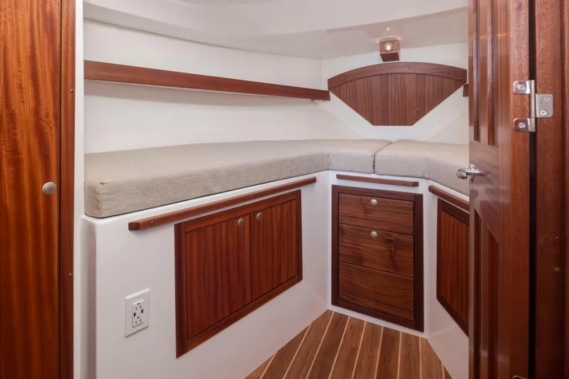  Yacht Photos Pics 2025 Ocean Sport Roamer cabin with wooden cabinetry and cushioned seating.