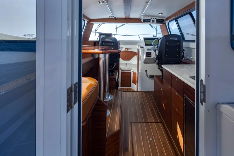  Yacht Photos Pics Interior of 2025 Ocean Sport Roamer boat with wood flooring and modern seating.