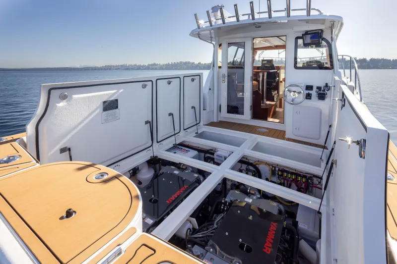  Yacht Photos Pics 2025 Ocean Sport Roamer boat with open engine compartment on calm water.