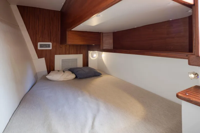  Yacht Photos Pics 2025 Ocean Sport Roamer cabin interior with cozy bed and wooden accents.