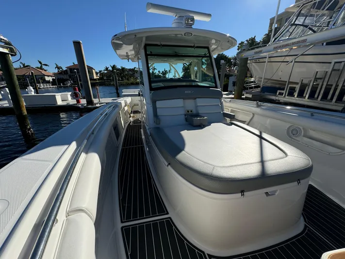  Yacht Photos Pics 2012 Boston Whaler 370 Outrage boat docked, showcasing sleek design and spacious deck.