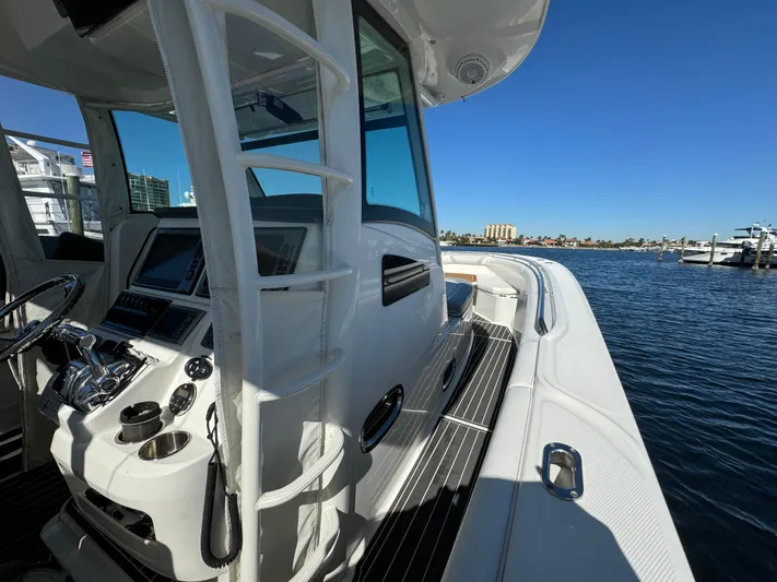  Yacht Photos Pics 2012 Boston Whaler 370 Outrage boat docked, showcasing helm and sleek design.