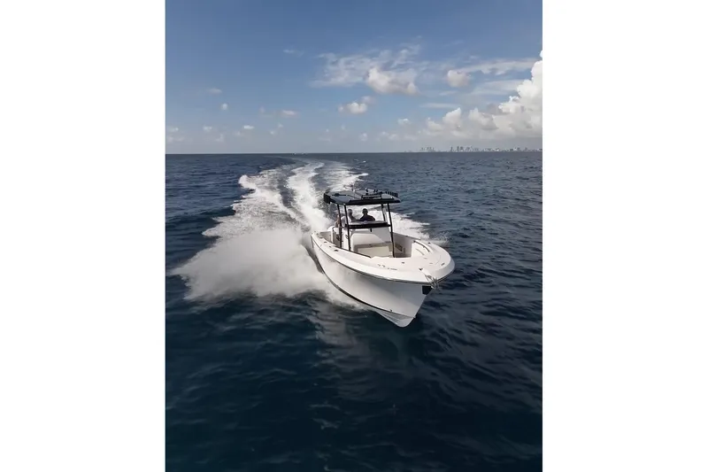  Yacht Photos Pics 2026 SeaWell 290CC boat cruising on open ocean under clear blue sky.