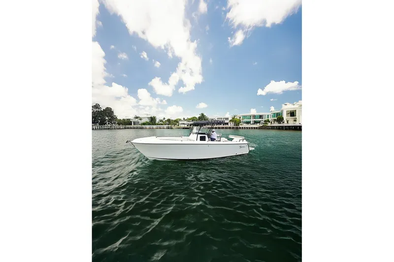  Yacht Photos Pics 2026 SeaWell 290CC boat cruising on a sunny day near waterfront homes.