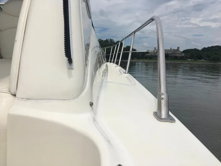  Yacht Photos Pics 2000 Sea Ray 410 Sundancer yacht deck with railing, calm water, and distant shoreline.